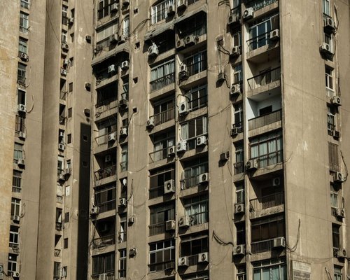 technician performing routine air conditioner cleaning in a Cairo apartment